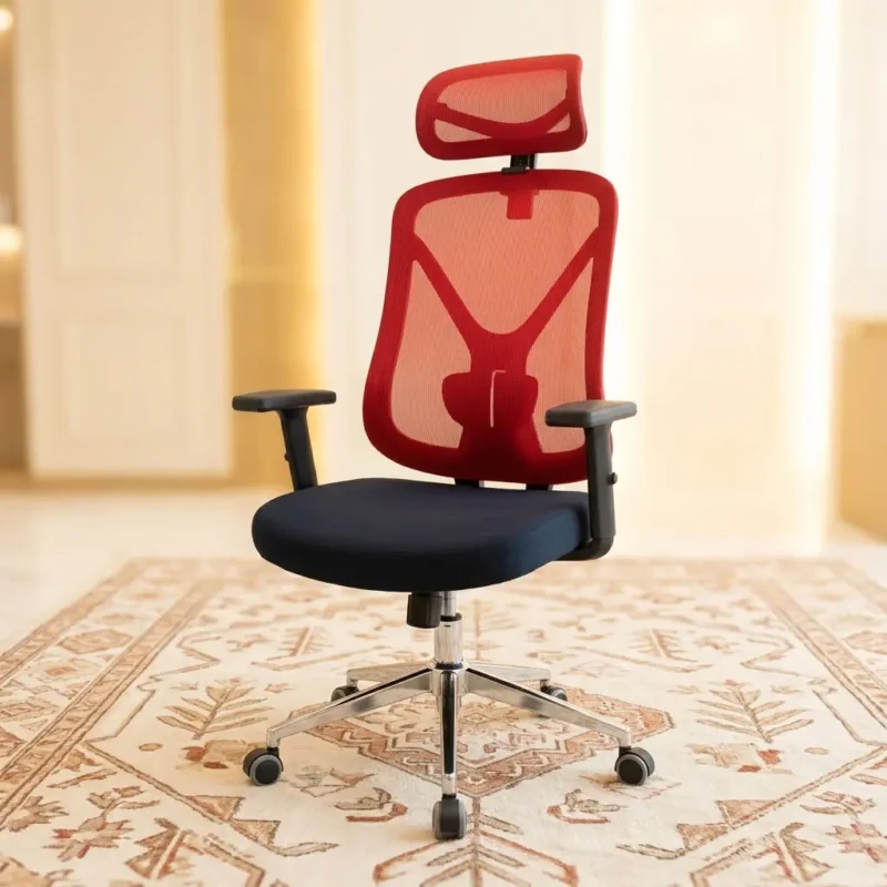 High-Back Ergonomic Red Mesh Executive Office Chair seen from the front with red mesh backrest, adjustable headrest, black cushioned seat, and polished chrome 5-star swivel base on an ornate rug